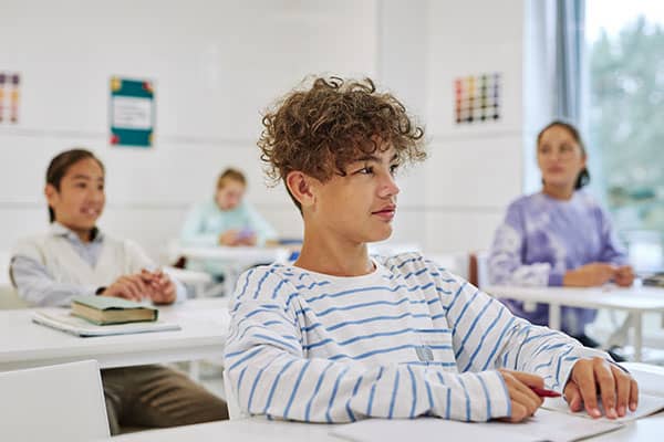 teenage boy sitting in classroom