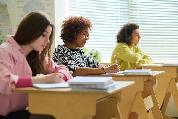 serious group of teen girls learning in classroom